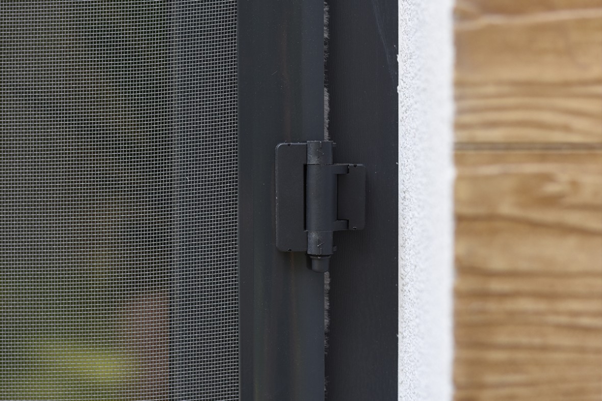 Estetyczny antracytowy zawias samodomykający moskitierę drzwiową. Umożliwia domykanie się moskitiery bez naszej ingerencji.