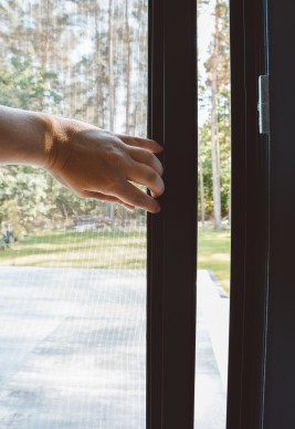 Otwieranie i zamykanie drzwi moskitierowych przesuwnych za ranty w profilu aluminiowym skrzydła.
