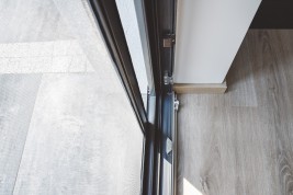 Otwarta antracytowa moskitiera drzwiowa przesuwna widok od środka.