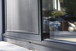 Prowadnica jezdna oraz skrzydło z siatką wykonaną z włókna szklanego w moskitierze drzwiowej przesuwnej jednoskrzydłowej.