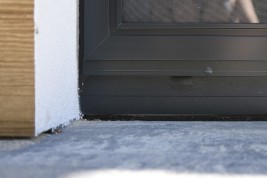 Prowadnica oraz zamknięte skrzydło moskitiery drzwiowej przesuwnej.