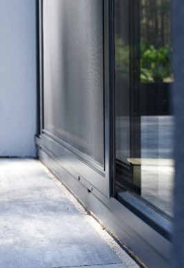 Prowadnica jezdna oraz skrzydło z siatką wykonaną z włókna szklanego w moskitierze drzwiowej przesuwnej jednoskrzydłowej.