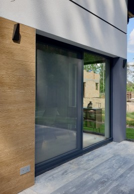 Moskitiera na drzwi tarasowe przesuwne o aluminiowej ramce oraz siatce z włókna szklanego odpornej na warunki atmosferyczne i odkształcenia.